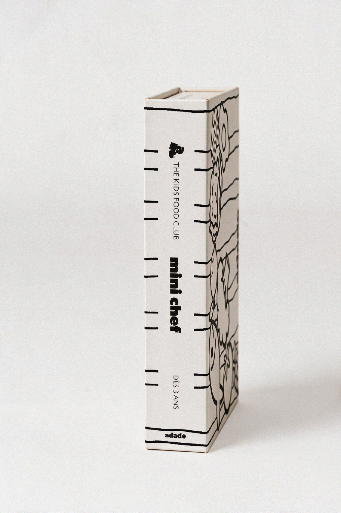 Box ADADE à colorier, décorée de rayures et d’illustrations de fruits et légumes en noir et blanc, pour une activité créative avec les enfants.