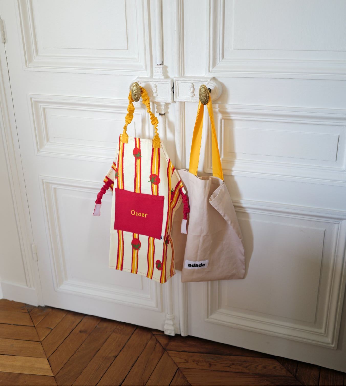 Tablier enfant tomates brodé prénom suspendu à une porte