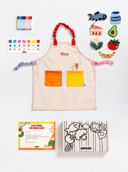 Box ADADE à colorier, décorée de rayures et d’illustrations de fruits et légumes en noir et blanc, pour une activité créative avec les enfants.